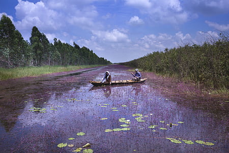 two person paddling boat in the middle of river thumbnail