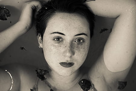 grayscale photography of woman half-soaked in water thumbnail