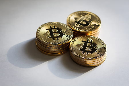 round gold-colored Bitcoins on white surface thumbnail
