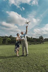 Man Standing Beside Woman Playing Drone thumbnail