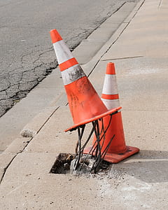 two orange traffic cones on concrete curb thumbnail