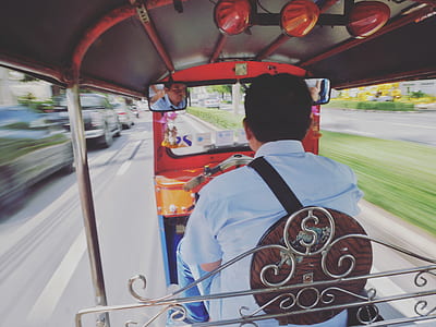 time lapse photography of man wearing white collared shirt inside auto rickshaw ruding daytime thumbnail