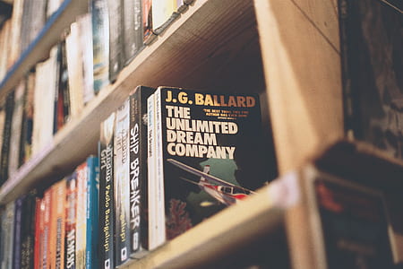 assorted-title books on brown wooden bookcase thumbnail