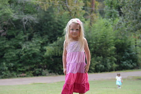 girl's white and pink spaghetti-strap dress near green leafed trees thumbnail