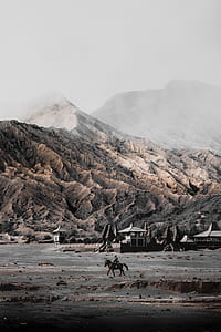 person riding horse near mountain thumbnail