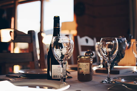 two wine glasses beside black glass liquor bottle thumbnail