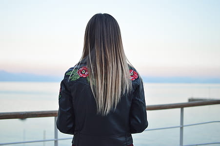 woman standing near fence looking at sea thumbnail