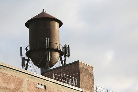 low-angle photography of gray rain water tank on top of building under nimbus clouds thumbnail