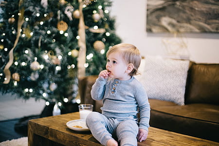 baby wearing gray long-sleeved shirt and pants sitting on brown wooden coffee table thumbnail