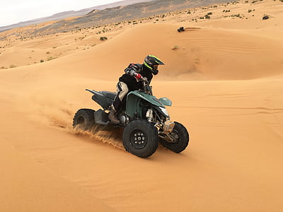 person riding on ATV surrounded by sands thumbnail
