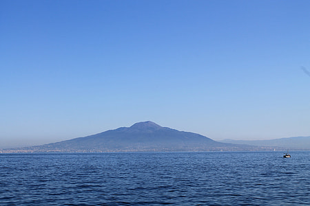 boat on wavy body of water under blue sky thumbnail