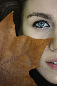 closed-up photo of brown maple leaf on woman's face thumbnail