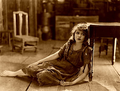 woman leaning on wooden table sepia photography thumbnail