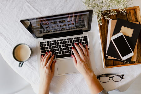 A woman works at a desk with a laptop and a cup of coffee thumbnail