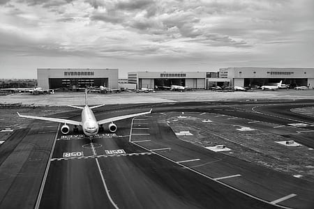 Gray Scale of Air Plane on Runway Under Cloudy Day thumbnail
