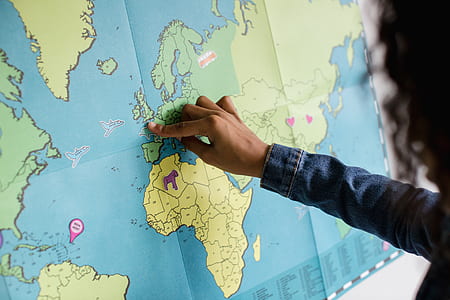 person sticking sticker on world map thumbnail