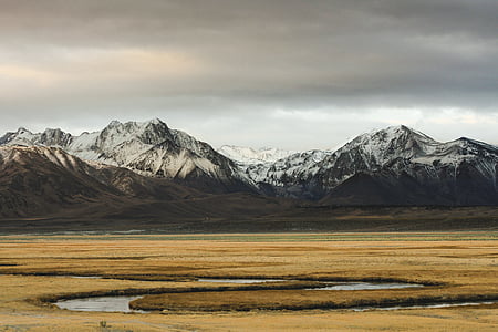 snow capped mountains under gray clouds thumbnail