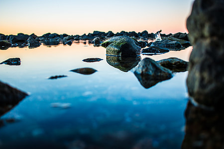 selective focus photography of rock on body of water thumbnail