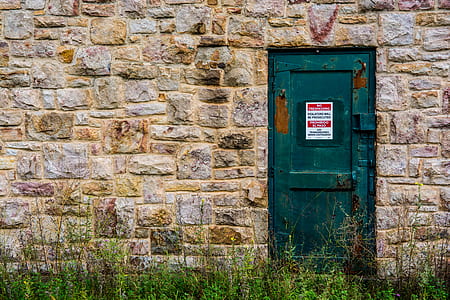 closed green door of brown concrete building thumbnail