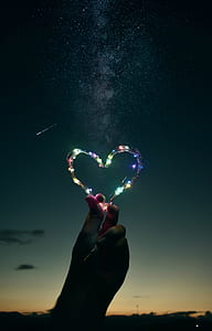 person holding heart-shaped string light thumbnail