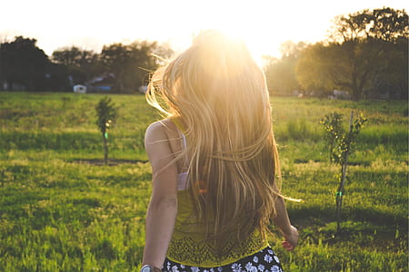 blonde-haired woman walking on green grass field thumbnail