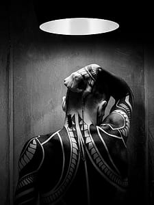grayscale photo of man covered in tattoo thumbnail