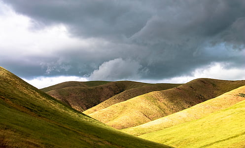 green grass field and mountain during daytime thumbnail