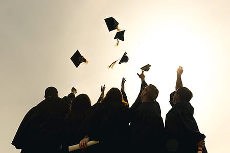 Grad Students Throwing Hats In The Air Photo thumbnail