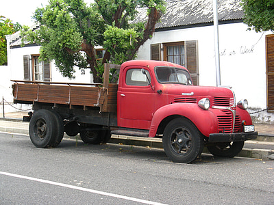 vintage red delivery truck on road side thumbnail