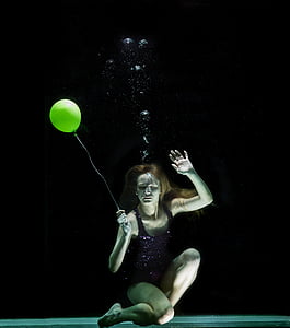 underwater photography of woman holding yellow balloon thumbnail