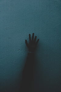 person's right hand touching blue wall thumbnail
