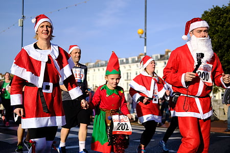 people wearing Santa Claus costumes walking on road thumbnail