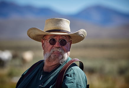 man wearing cowboy hat near mountains thumbnail