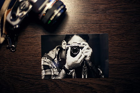 man holding black camera illustration on brown surface thumbnail