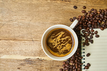photo of white ceramic mug beside coffee beans thumbnail