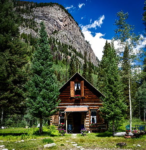 brown house near rock formation landscape photo thumbnail