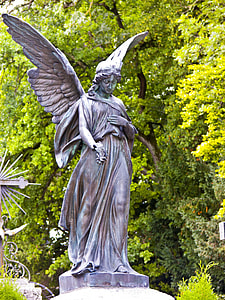 concrete statue of woman angel near green trees during daytime thumbnail
