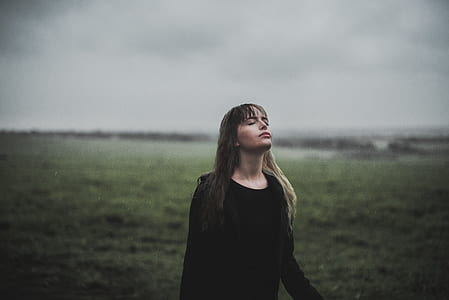 woman closing eyes standing in open area thumbnail