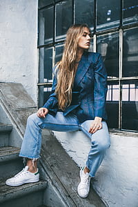 woman looking side while sitting on white concrete window while talking a photo thumbnail