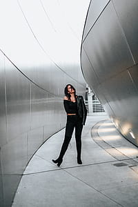 woman wearing black top standing near concrete wall thumbnail