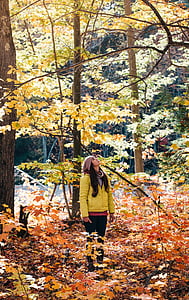 woman standing looking above surrounded by trees thumbnail