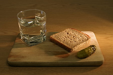 clear glass cup with water beside loaf bread on wooden board thumbnail