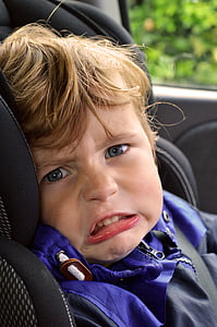 boy in blue and black jacket on black convertible car seat thumbnail