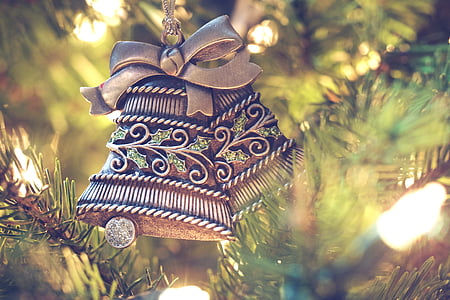 selective focus photo of hanged gold-colored decorative bells near plant thumbnail