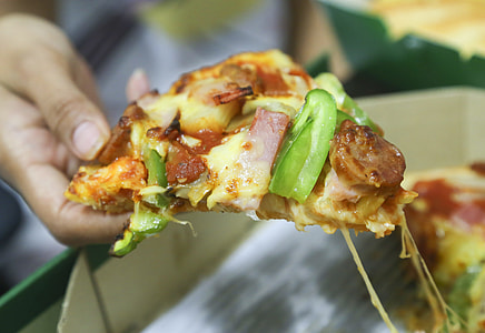 person holding sliced of pizza thumbnail