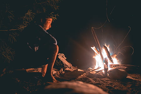 man sits near fire thumbnail