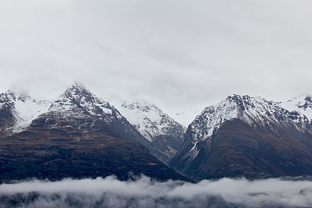 brown and white mountains above clouds thumbnail