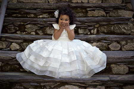 girl in white crew-neck cap-sleeved mini dress sitting on brown stairs thumbnail