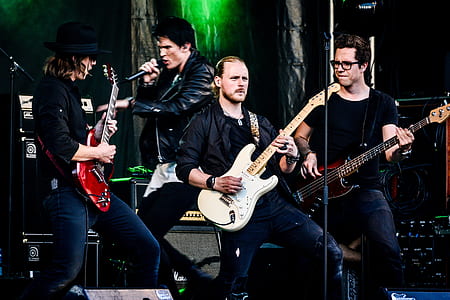 four men band performing on stage thumbnail