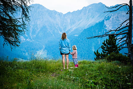 woman and girl standing on the grass land during daytime thumbnail
